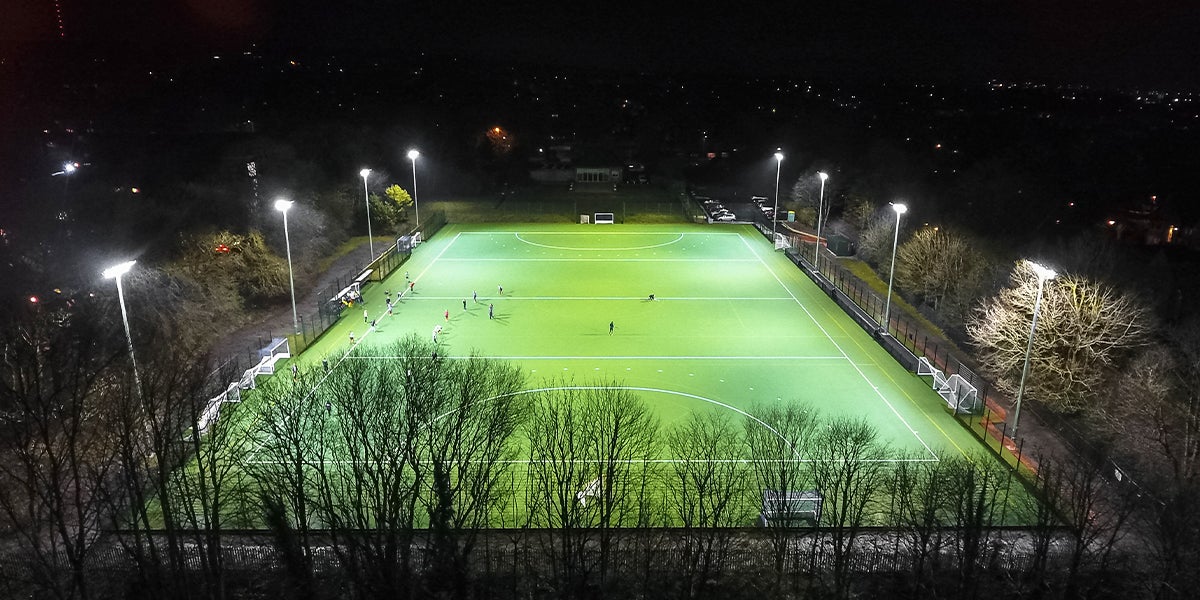Bolton School  hockey pitch - Green Pitch in surrounded by trees 